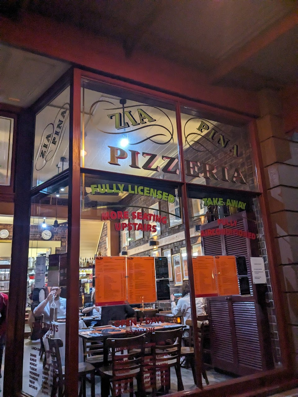 Pizza served on a round wooden tray at Zia Pina Pizzeria